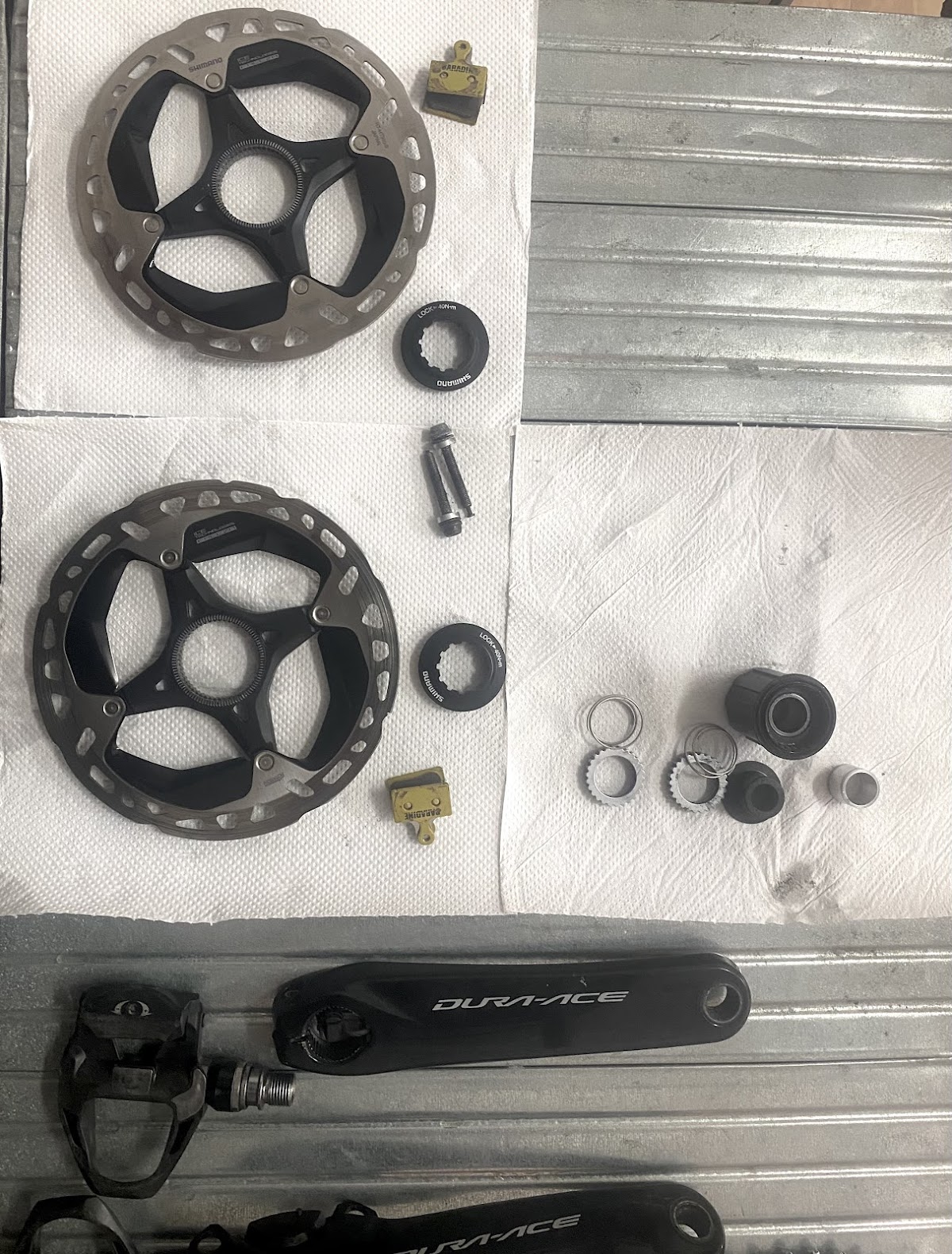 Shimano Dura-Ace cranks, rotors and small parts laid out on clean towels