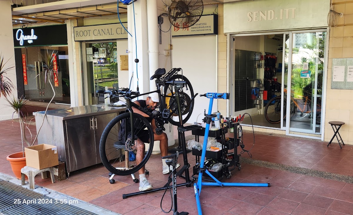 Send Itt shopfront with mechanic working at the repair stands