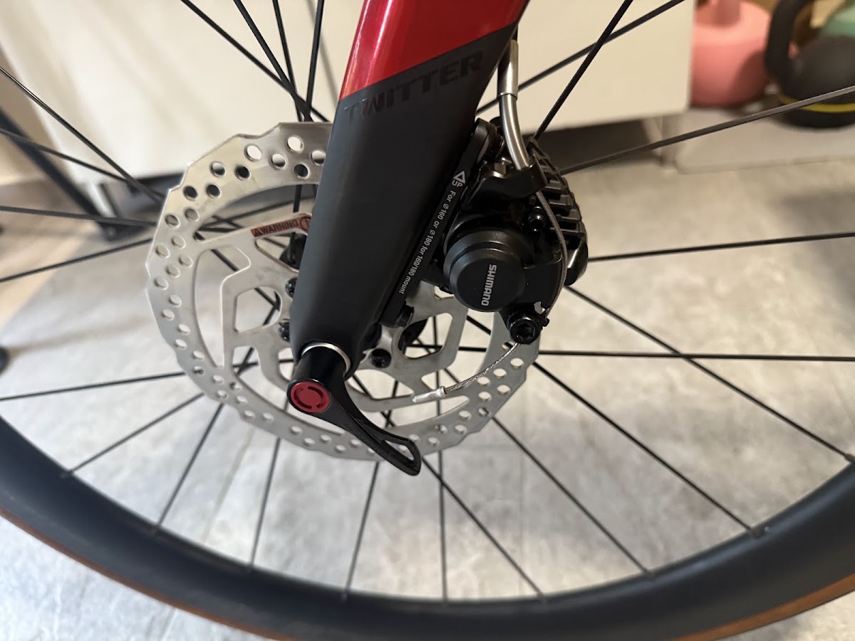 Shimano disc brake caliper and rotor close up on a red fork